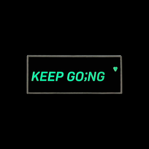 Black and white glow-in-the-dark PVC patch that says Keep Going with velcro hook backing